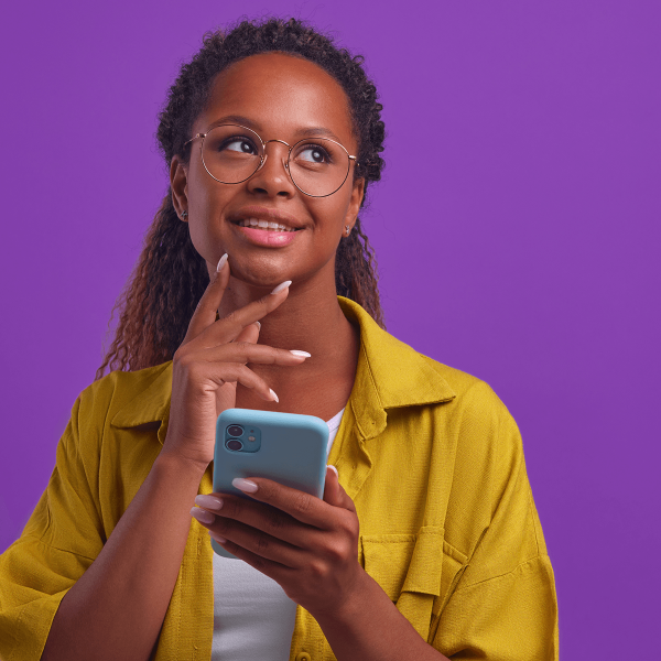 Femme songeant et tenant un mobile dans la main