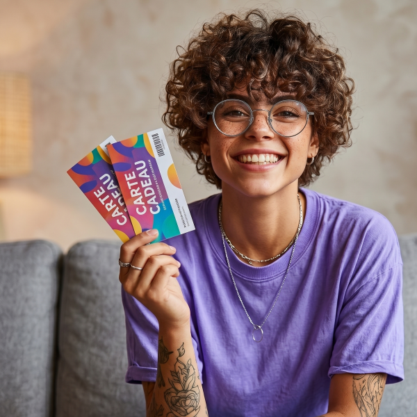 jeune femme tenant des cheques cadeau